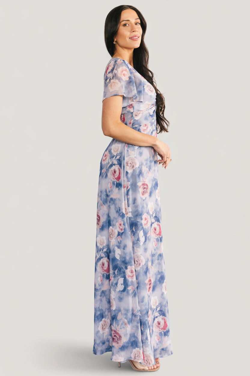 Detail image focusing on fabric texture and print of the Promise Maxi Dress, illustrating the chiffon weave and pink floral pattern on dusty blue.