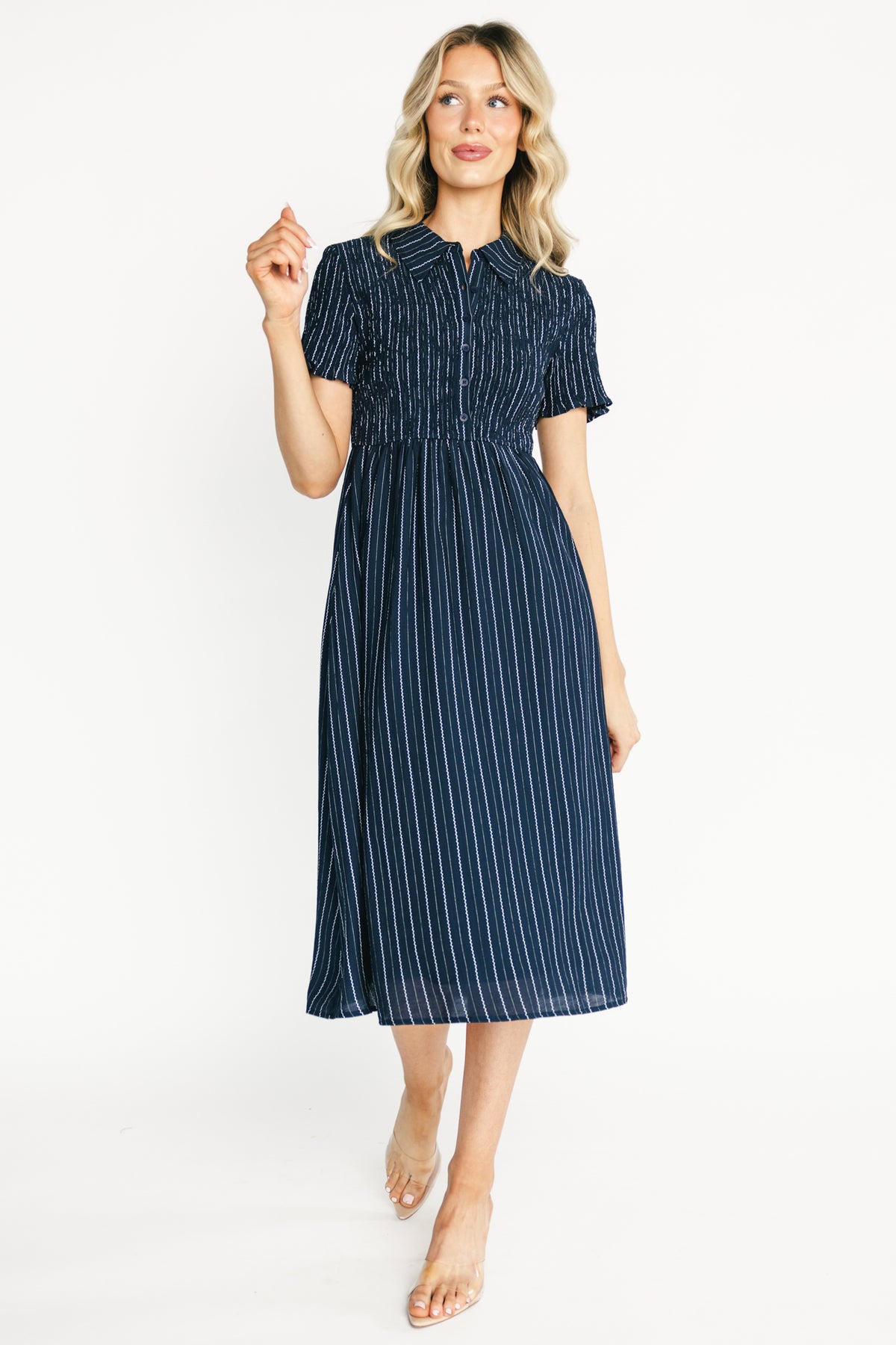 Front view of navy Dottie striped midi dress showing collared neckline, functional buttons, smocked bodice and A-line midi skirt for polished wear.