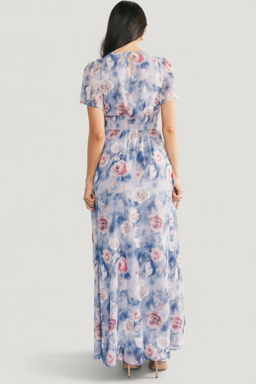 Back view of the Promise Maxi Dress in dusty blue floral displaying the keyhole with button closure and smocked elastic at the back waist.