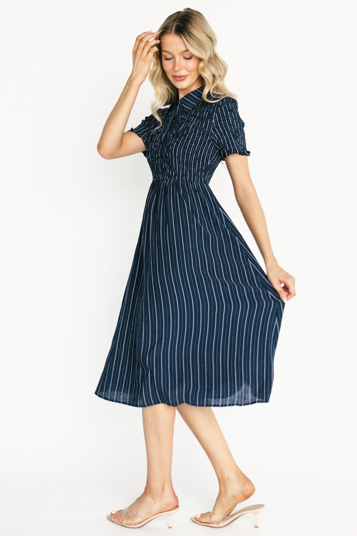 Back view of navy Dottie striped midi dress showing back silhouette, elasticated waist and smooth lined skirt with clean hemline.