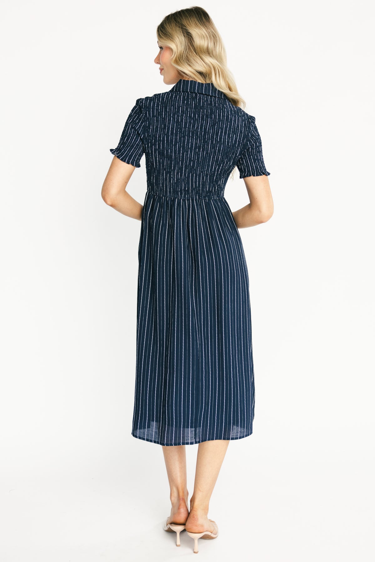 Detail shot of collared neckline, functional bodice buttons and short smocked sleeve on the Dottie navy striped midi dress.