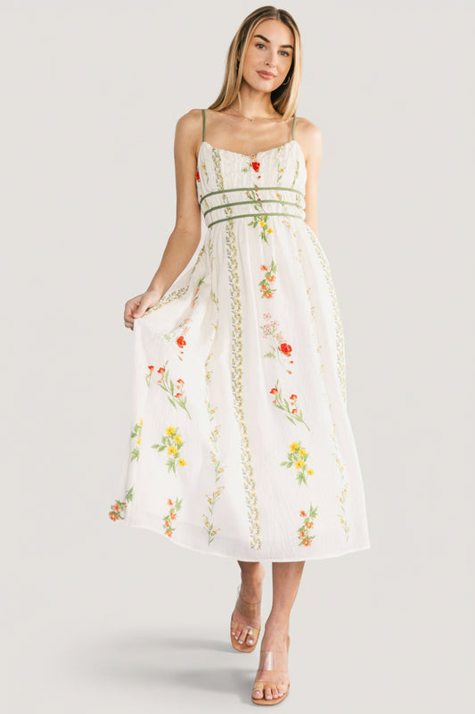 Front view of Cerise Midi Dress on model; ivory base with green, yellow and orange floral print, midi length and V-neck detailing.