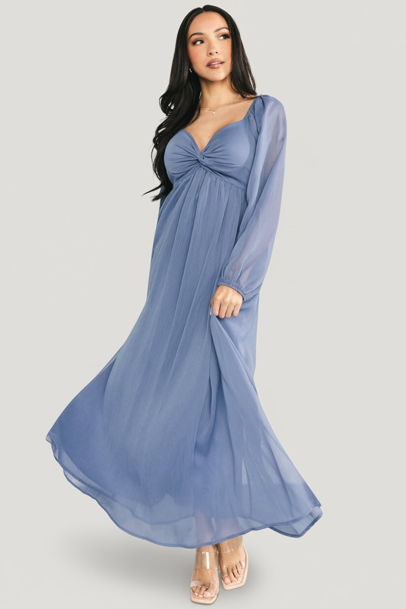 Three-quarter view of the Dione midi dress in dusty blue showing puffed sleeve detail, smocked back and soft georgette drape.