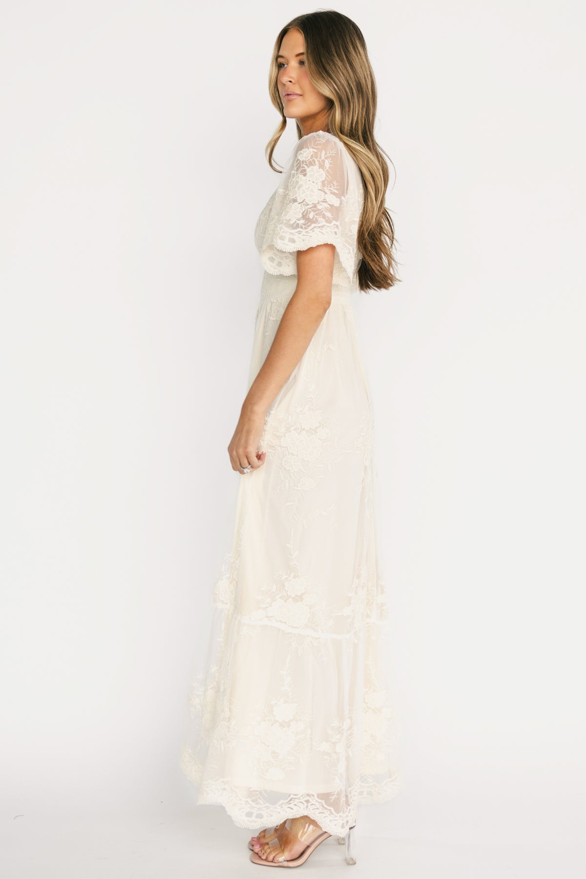 Close-up detail of crochet circle trim along the V-neckline and embroidered lace texture in vintage cream fabric for an elegant finish.