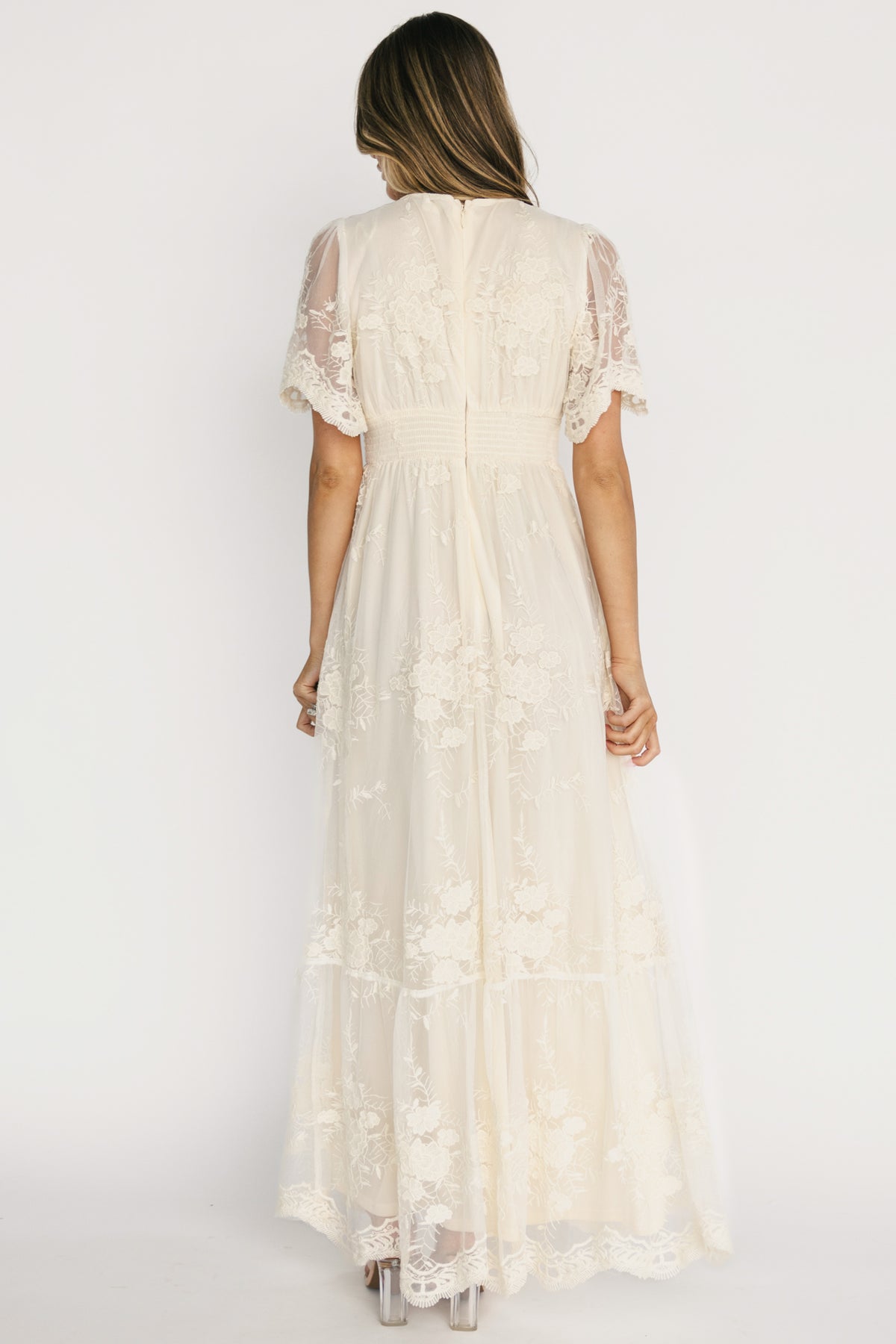 Back view of Rosalia Lace Maxi Dress displaying back zipper with hook-and-eye, smocked waist panel, and scalloped hemline detail.