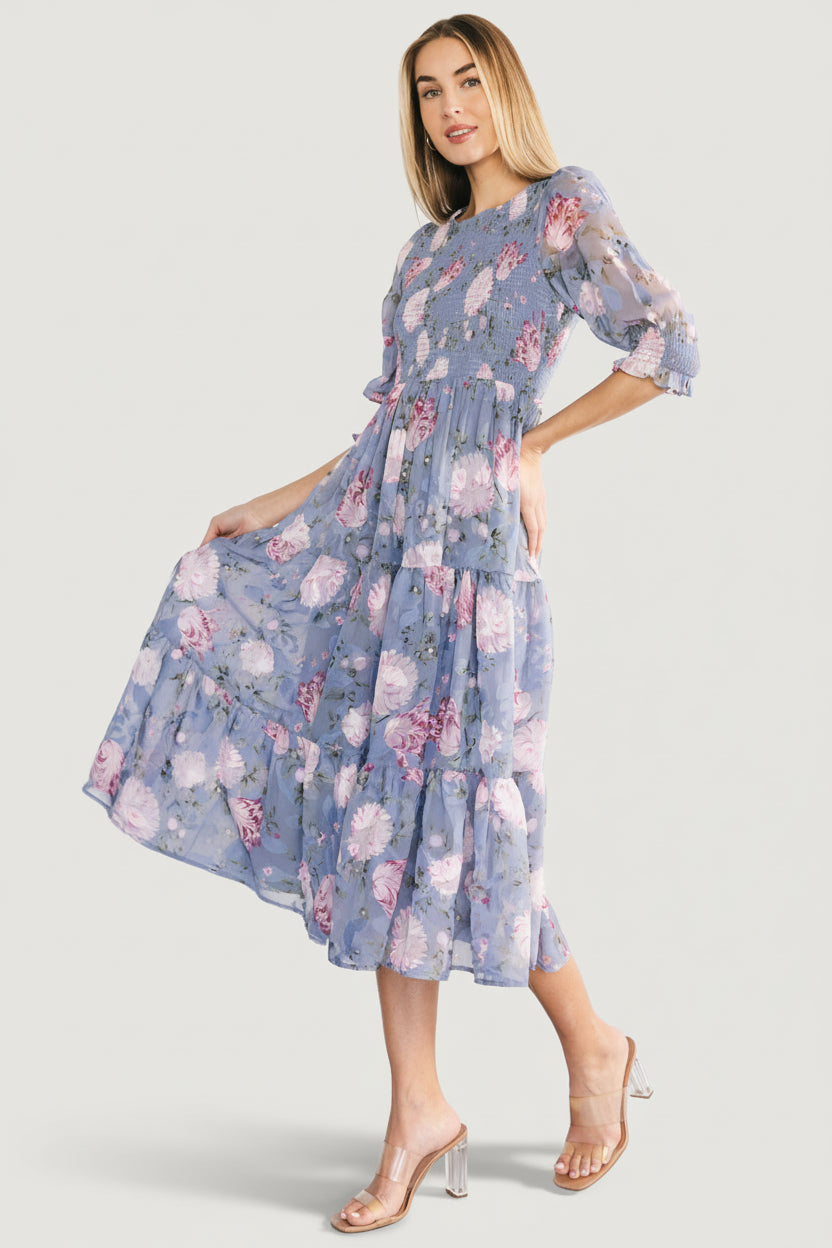 Model wearing the Nellie dress outdoors, styling suggestion with sandals, showcasing print scale and midi length on body.