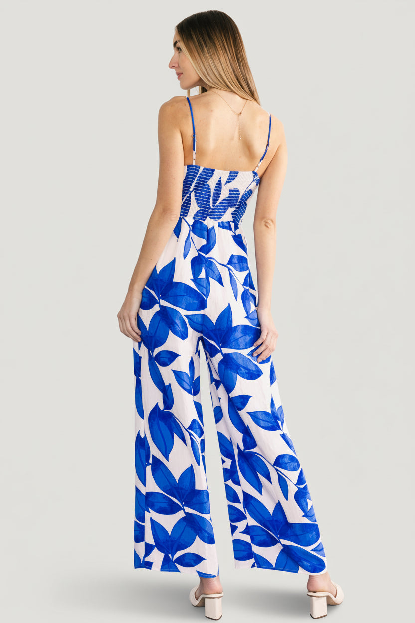 Back view of Noémie Jumpsuit highlighting smocked back panel and adjustable straps in cobalt leaf print.