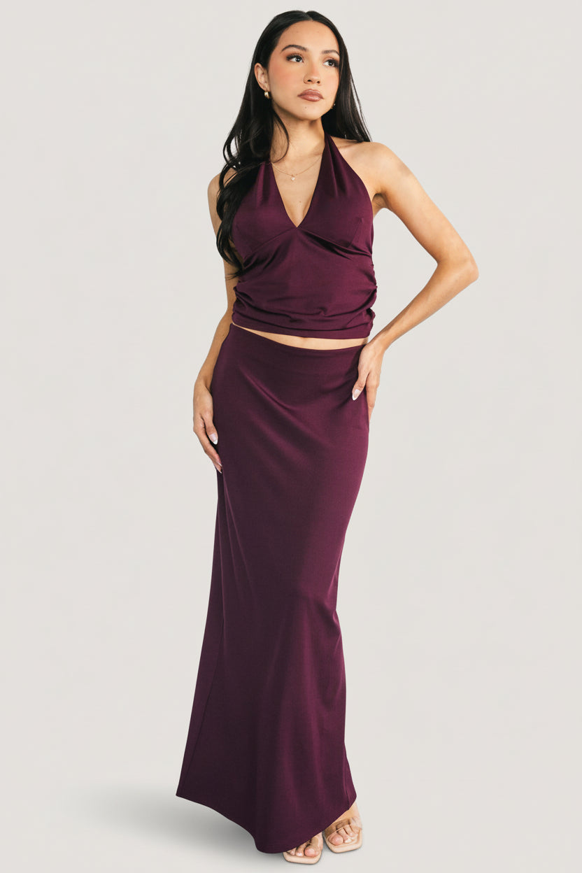 Close-up of the halter top in mulberry, showing V-neckline, side ruching, and bust dart detail in stretch jersey fabric.