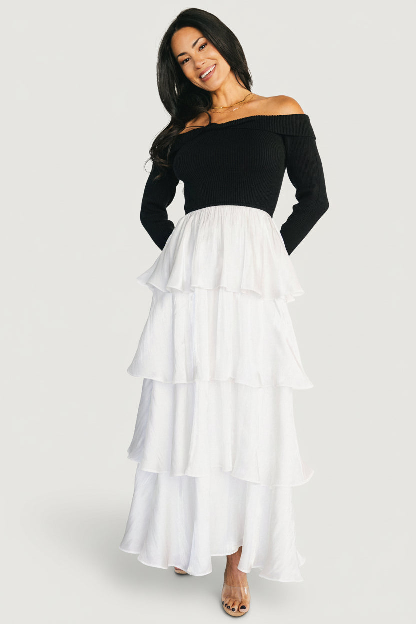 Full-length portrait of model wearing Maelie Tiered Maxi Dress; elegant contrast of fitted bodice and flowing tiered skirt.
