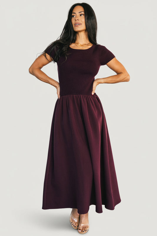 Front view of model wearing Angelique Midi Dress in mulberry; ribbed sweater top, drop-waist elastic band, thick jersey midi skirt