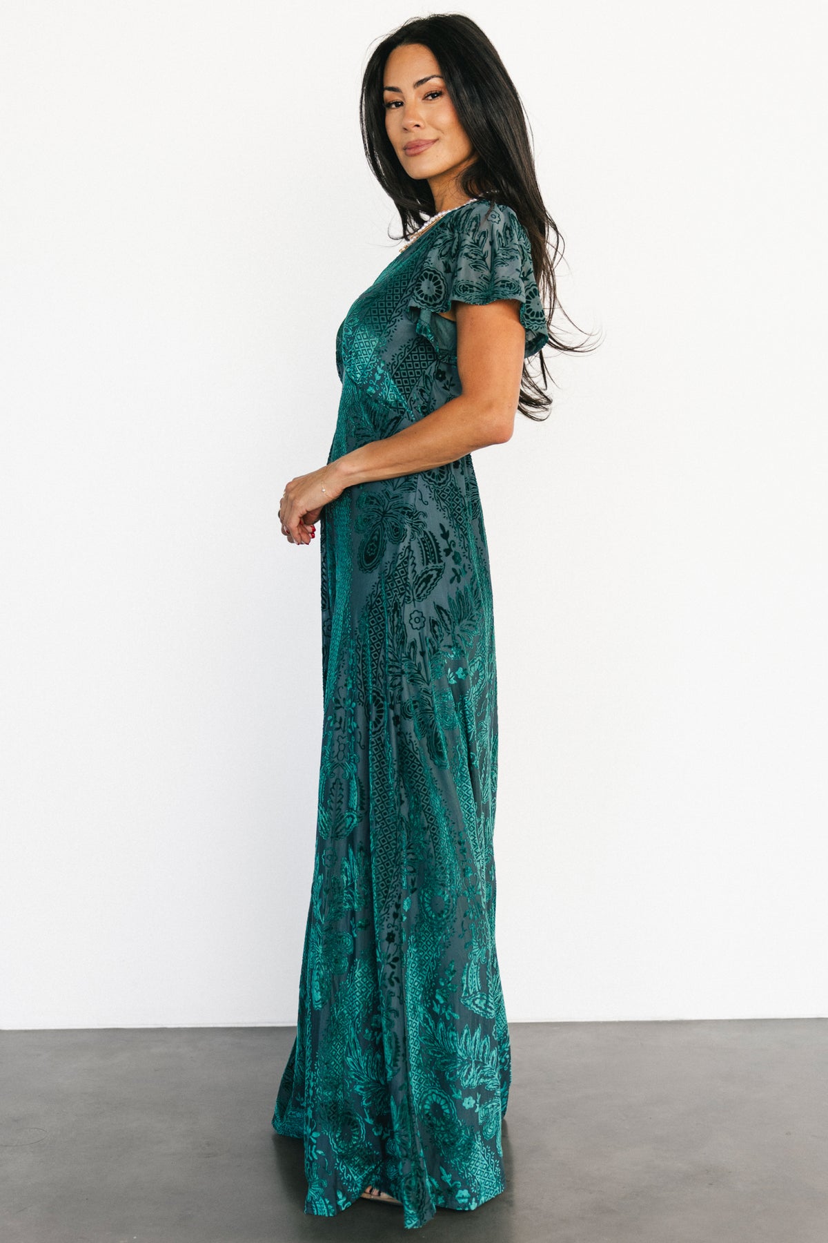 Back and side view of the emerald Kimberly velvet burnout maxi dress, showing skirt drape and subtle sheen of the velvet pattern.