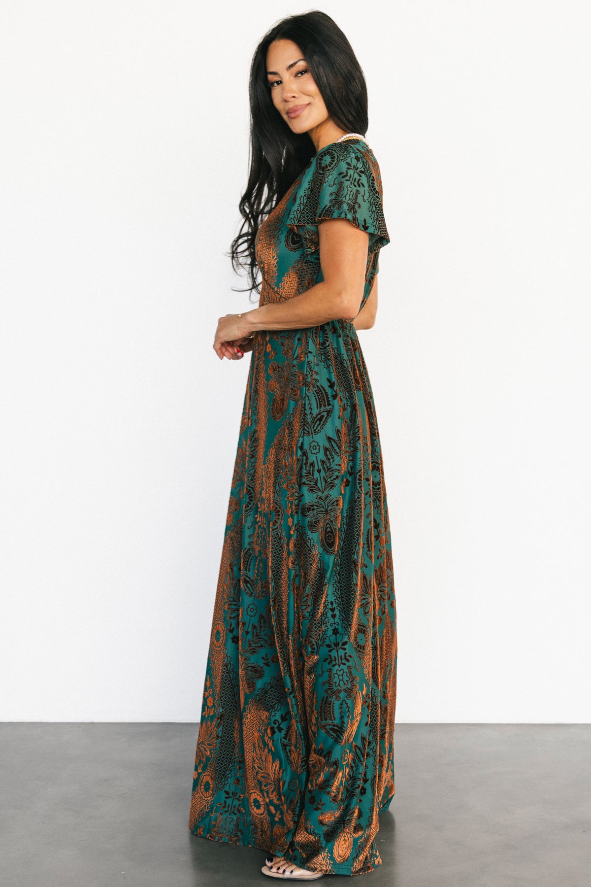 Close-up of the burnout velvet floral texture on the Kimberly maxi dress, highlighting bronze flocking on a jade mesh base.