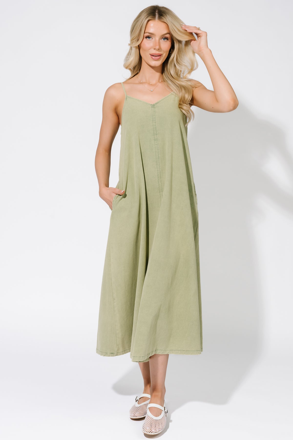 Close-up of fabric and hidden side pocket detail on the Marcia Maxi Dress, showing green wash cotton texture and stitch details.