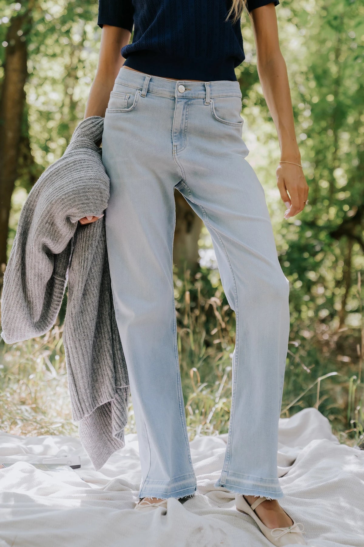 Bria High Rise Wide Leg Jeans in Light Wash with relaxed wide legs, front and back pockets, button closure, and raw hem.