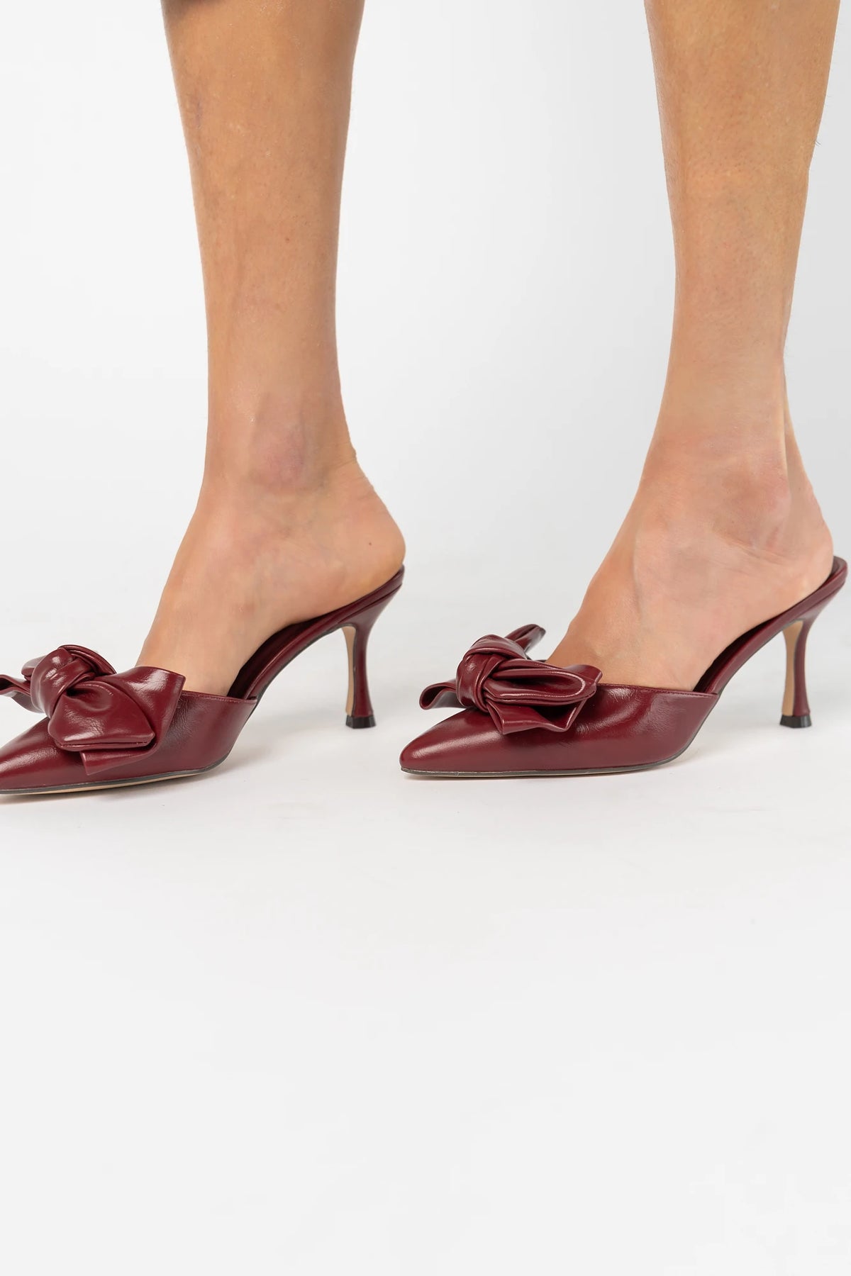 Montara Pointed Toe Kitten Heel in Burgundy with faux leather finish, statement bow, slip-on mule design, and kitten heel.