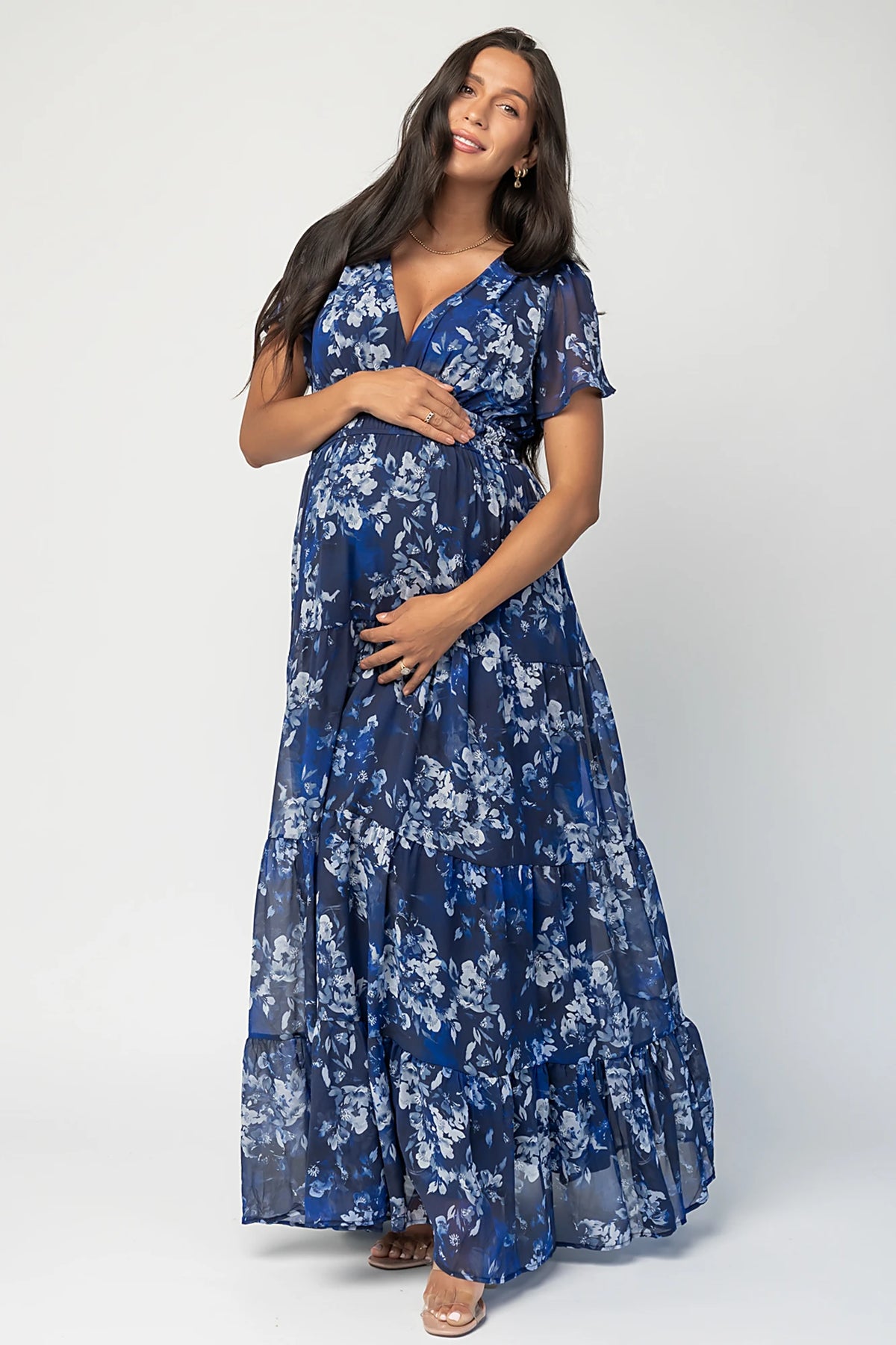 Blue floral chiffon maxi dress with flutter sleeves, surplice V-neck, smocked elastic waist, tiered skirt, and lined body.