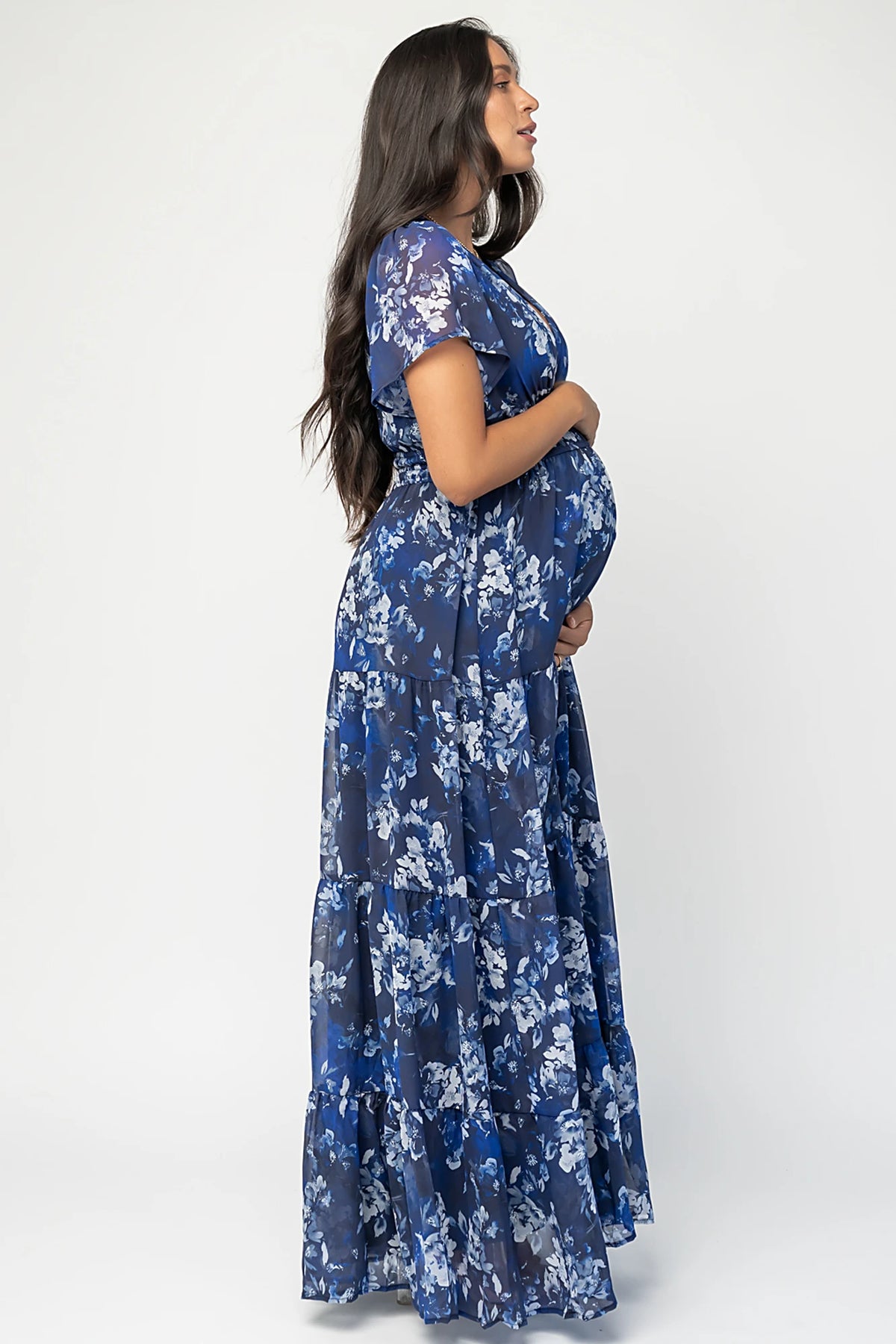 Blue floral chiffon maxi dress with flutter sleeves, surplice V-neck, smocked elastic waist, tiered skirt, and lined body.