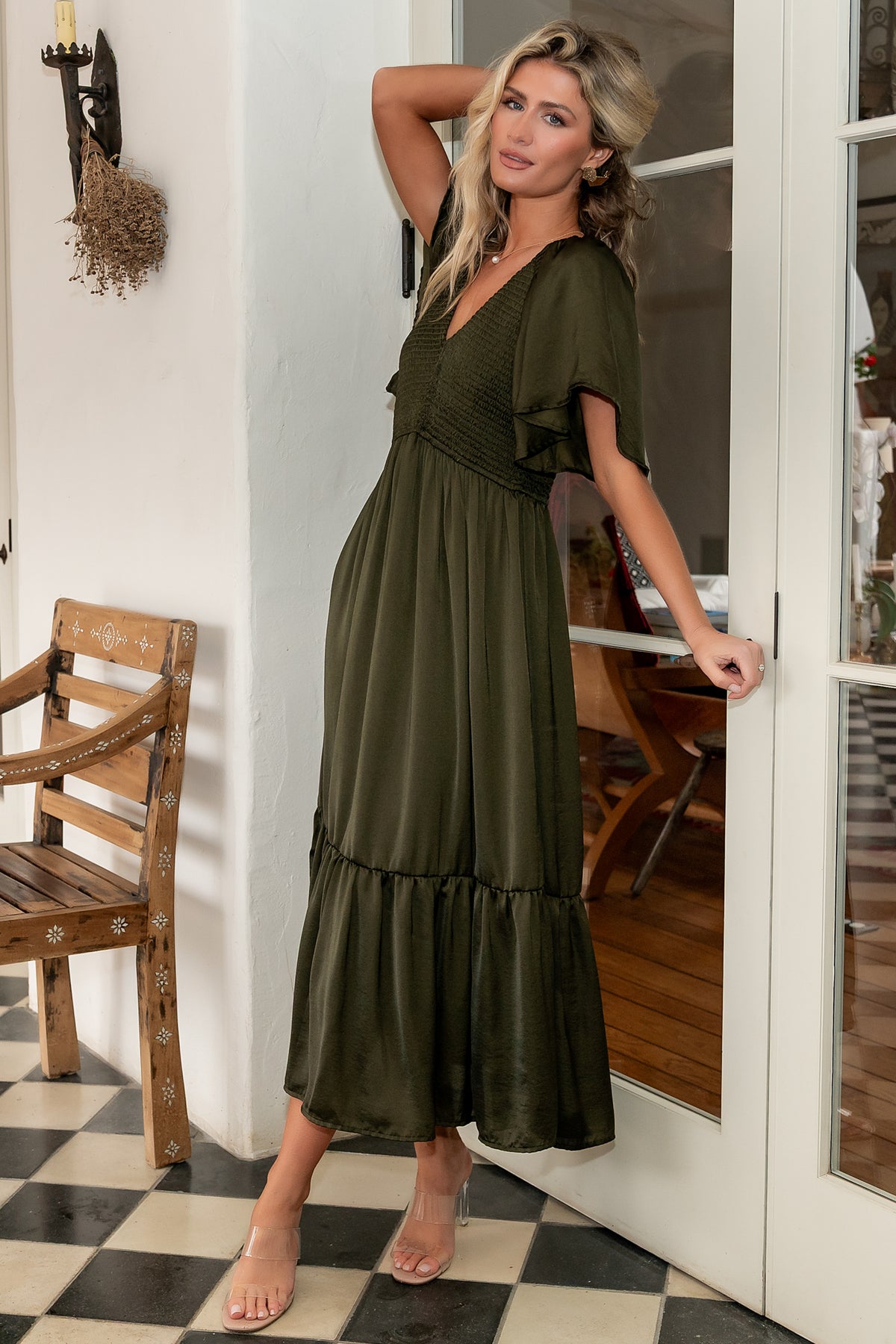 Front view of Lovell smocked midi dress in deep olive showing smocked bodice, rounded V neckline, flutter sleeves, and midi ruffle hem.