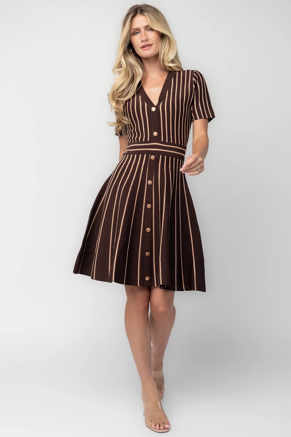 Model wearing the Tate Striped Short Dress in Brown + Beige featuring a soft sweater knit with beige vertical stripes.