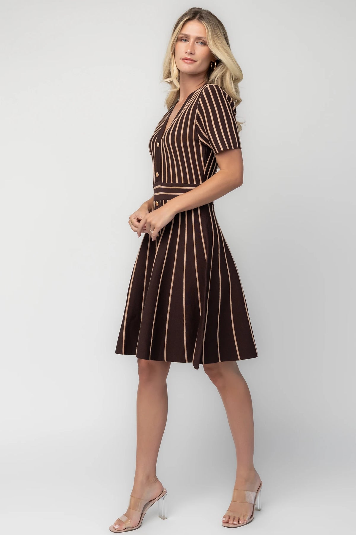 Model wearing the Tate Striped Short Dress in Brown + Beige featuring a soft sweater knit with beige vertical stripes.
