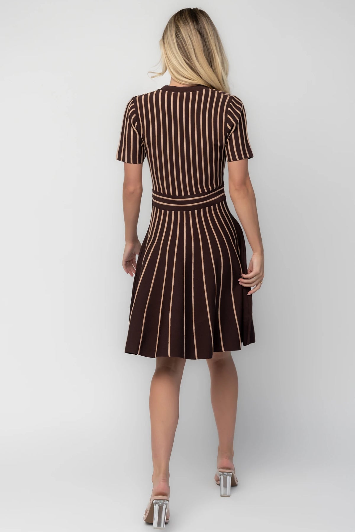Model wearing the Tate Striped Short Dress in Brown + Beige featuring a soft sweater knit with beige vertical stripes.