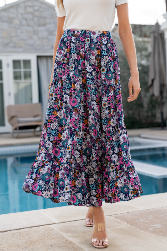 Front view of navy floral maxi skirt on a model, showing full length, print detail, and smocked back waistband.