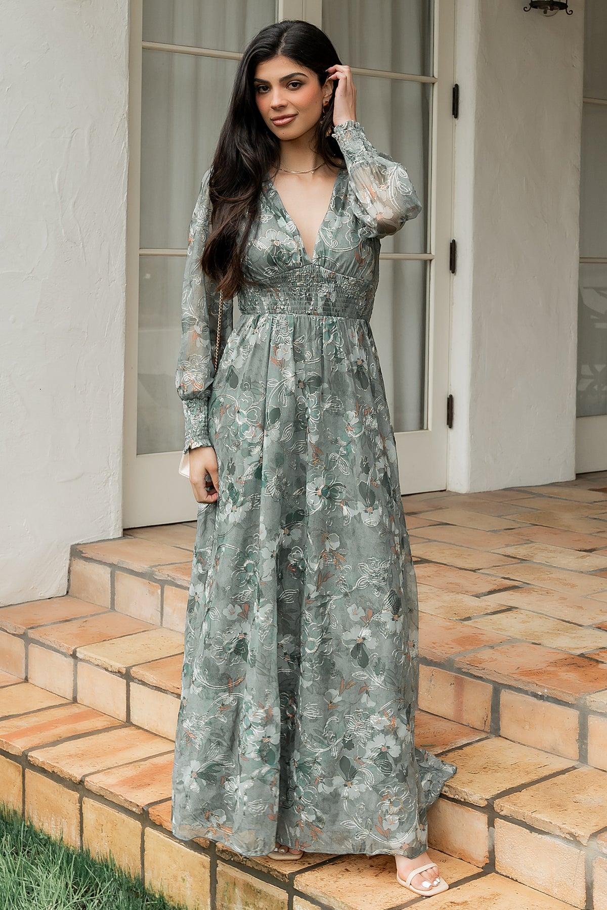 Front view of sage tulle maxi dress with gold embroidered florals, deep V-neck, smocked waist and long sheer sleeves.