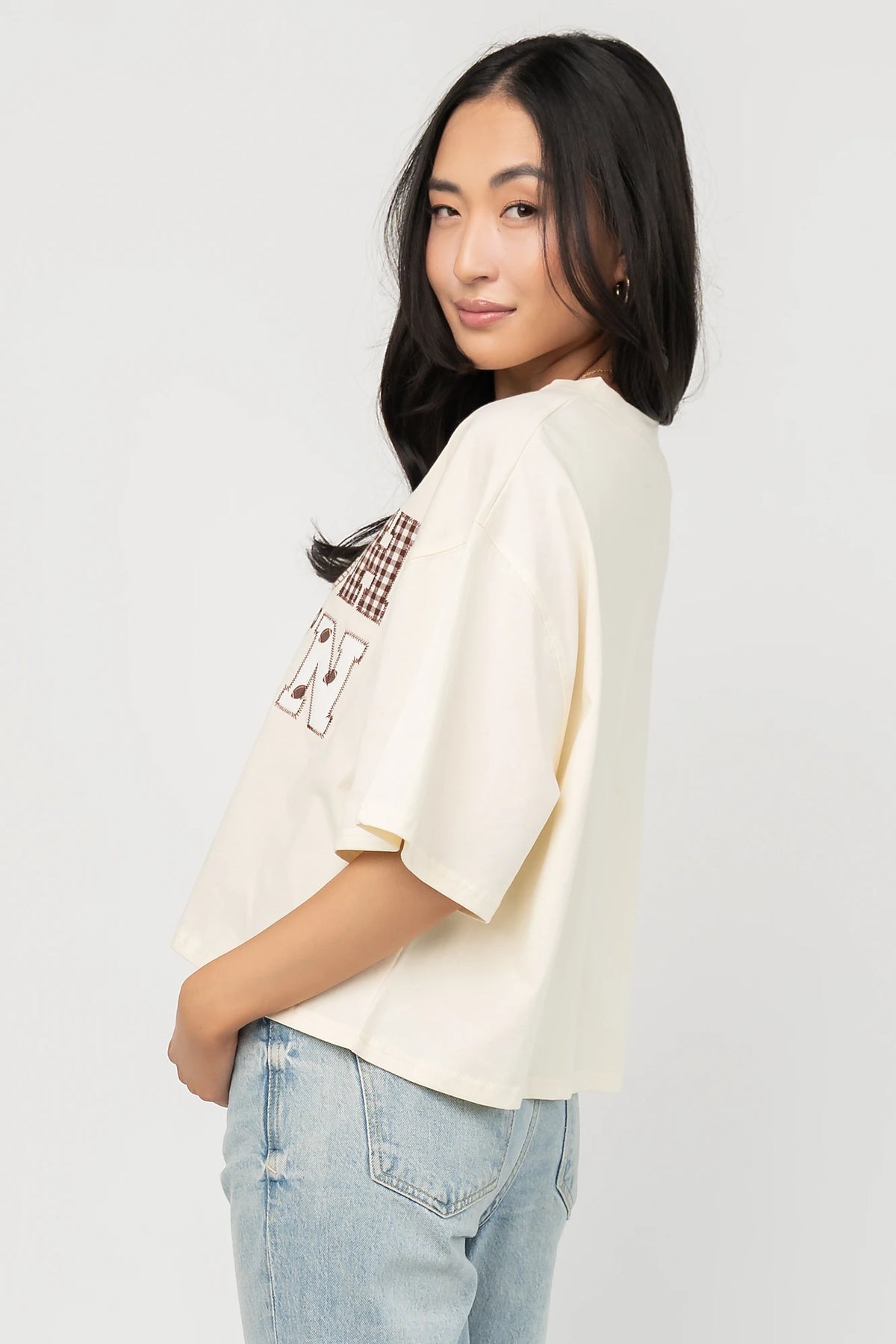 Jason Graphic Tee in Cream with vintage football graphic, gingham, lace and bow appliqué, crew neckline, and short sleeves.