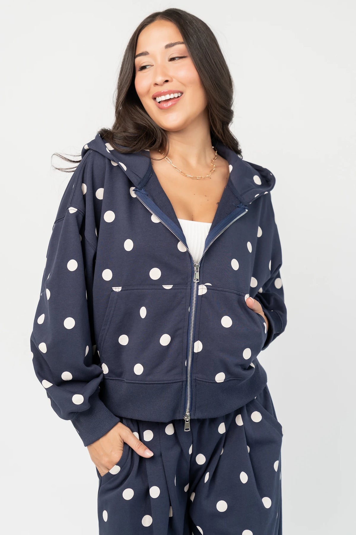Lydia Zip Up Hoodie in Navy Dot with polka dot print, oversized fit, adjustable hood, zip front, and kangaroo pockets.