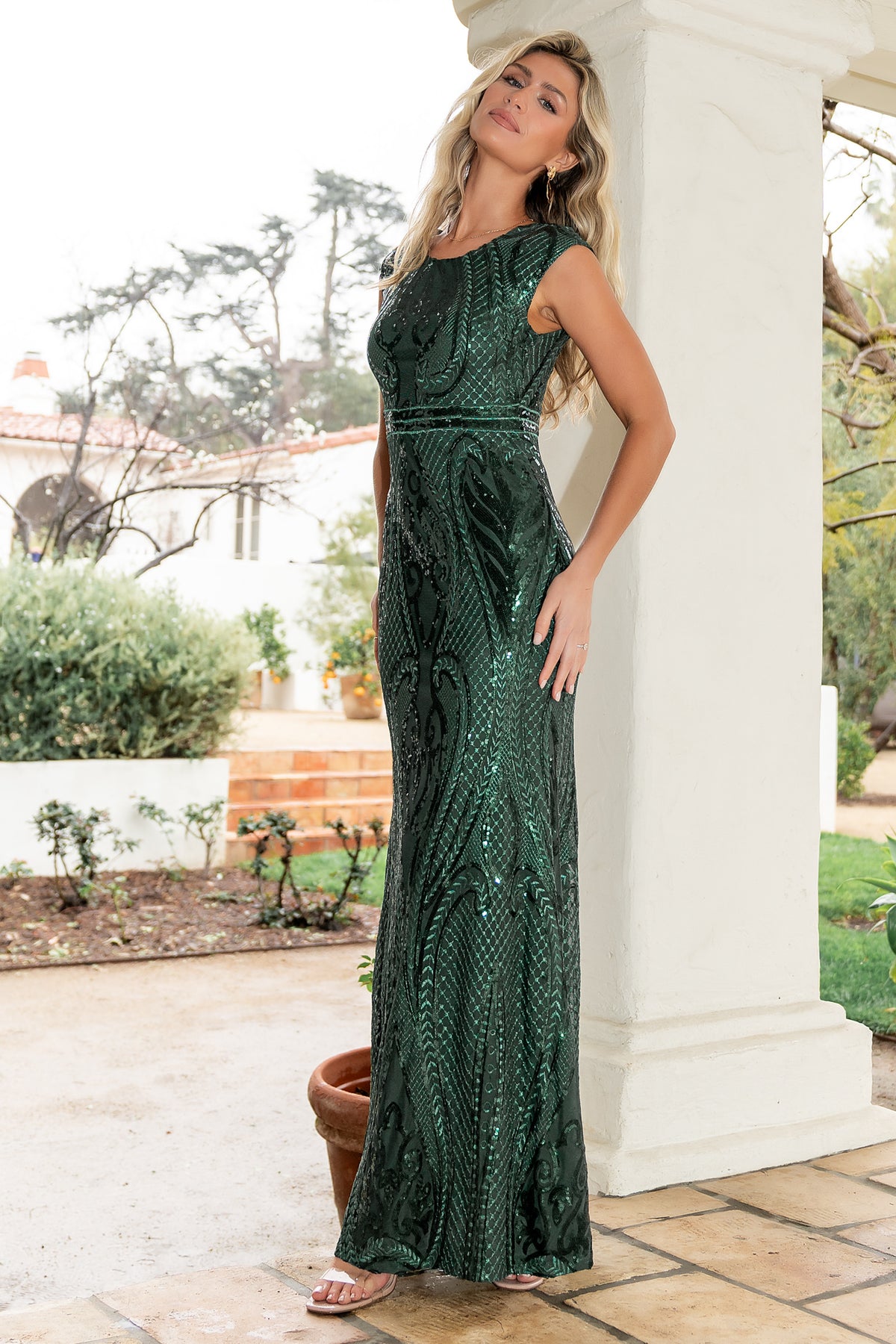 Model wearing Alessia green sequin gown in motion, highlighting the mermaid silhouette, skirt movement, and overall evening wear elegance.