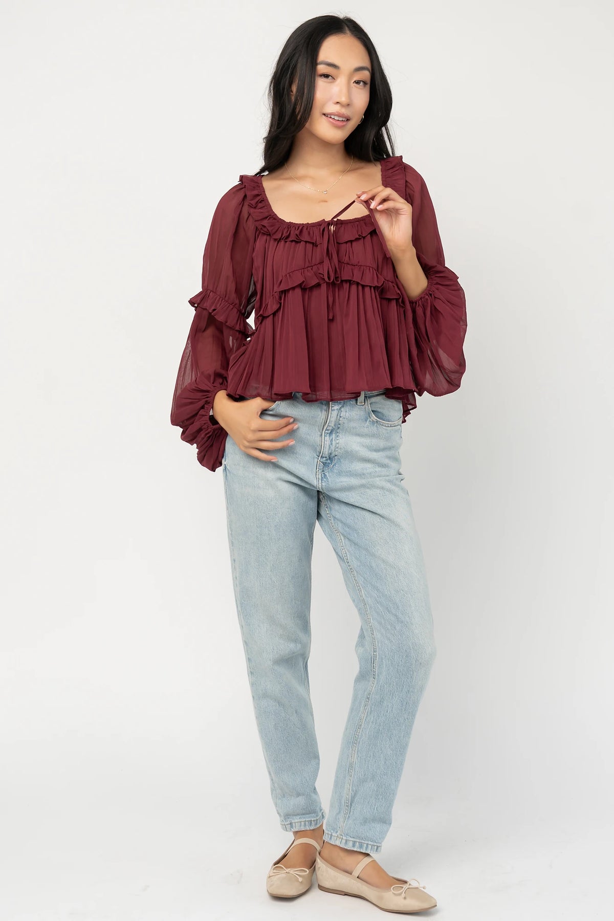 Bellerose Ruffle Top in Burgundy with pleated chiffon, ruffle-trimmed neckline, front tie, and billowy long sleeves.