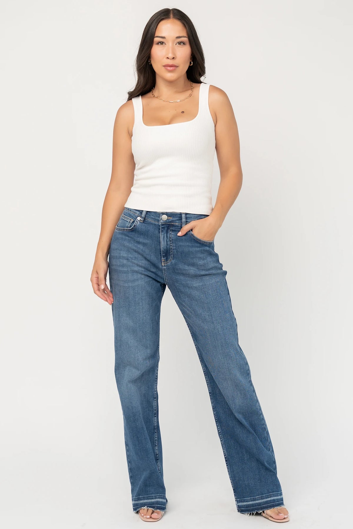 Bria High Rise Wide Leg Jeans in Medium Wash with relaxed wide legs, front and back pockets, button closure, and raw hem.