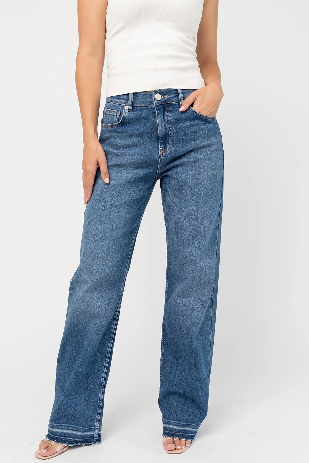 Bria High Rise Wide Leg Jeans in Medium Wash with relaxed wide legs, front and back pockets, button closure, and raw hem.