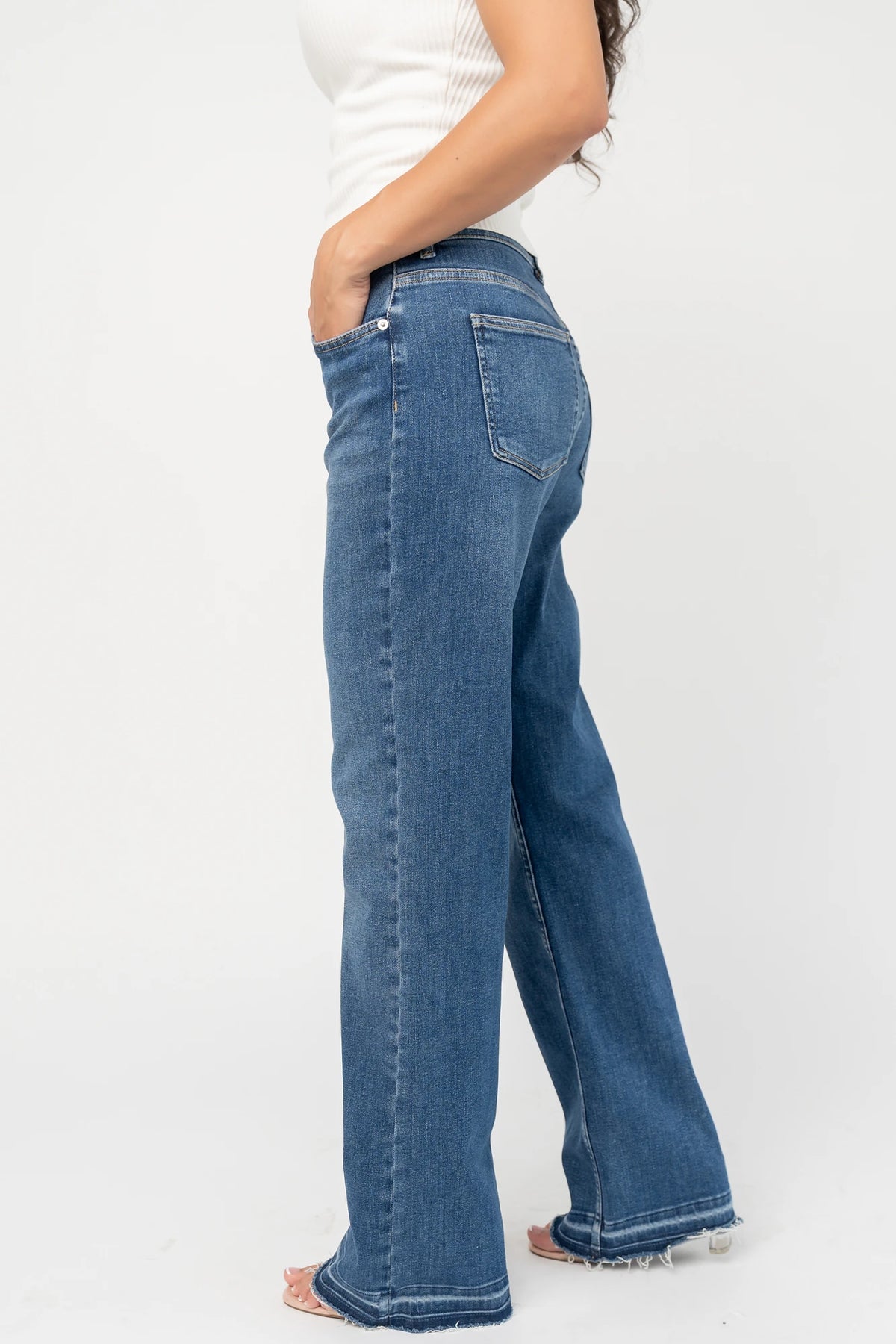 Bria High Rise Wide Leg Jeans in Medium Wash with relaxed wide legs, front and back pockets, button closure, and raw hem.