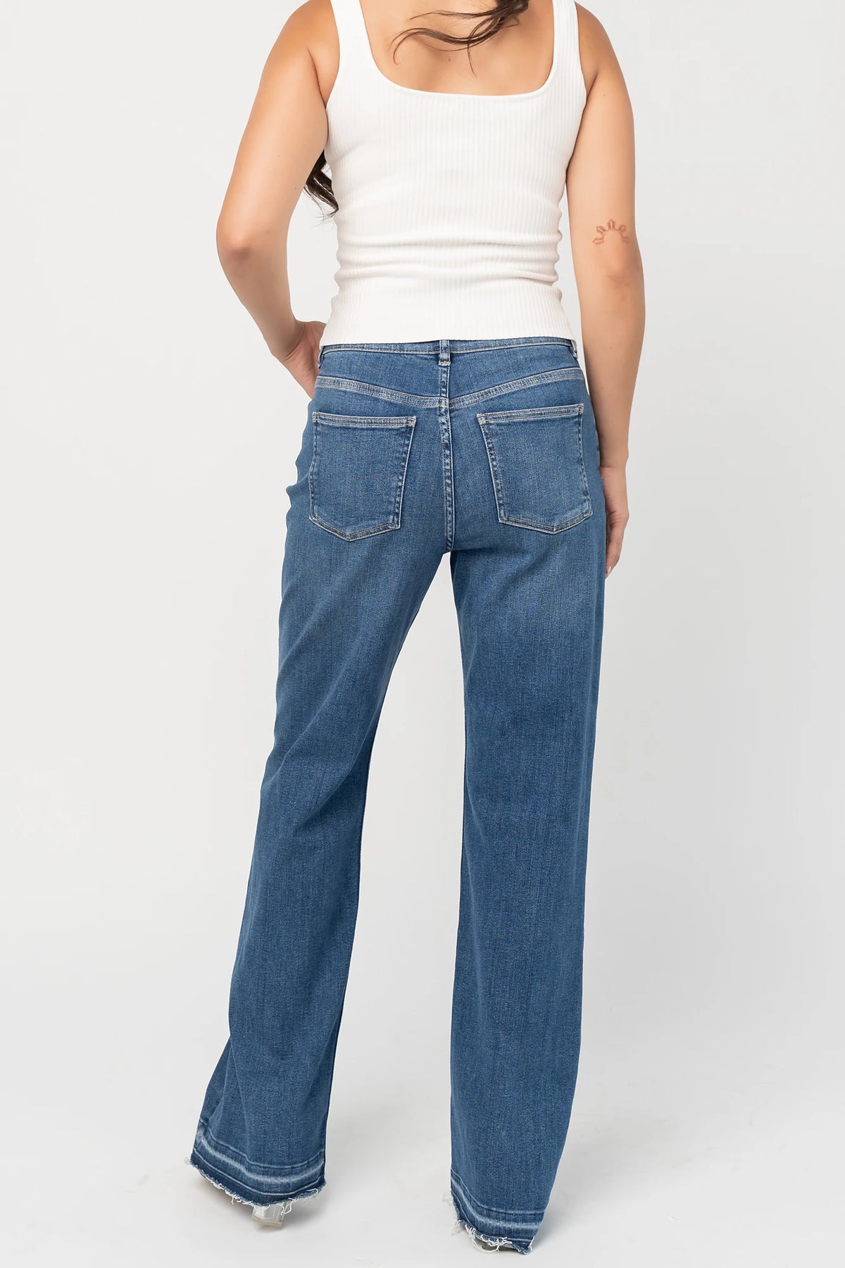 Bria High Rise Wide Leg Jeans in Medium Wash with relaxed wide legs, front and back pockets, button closure, and raw hem.