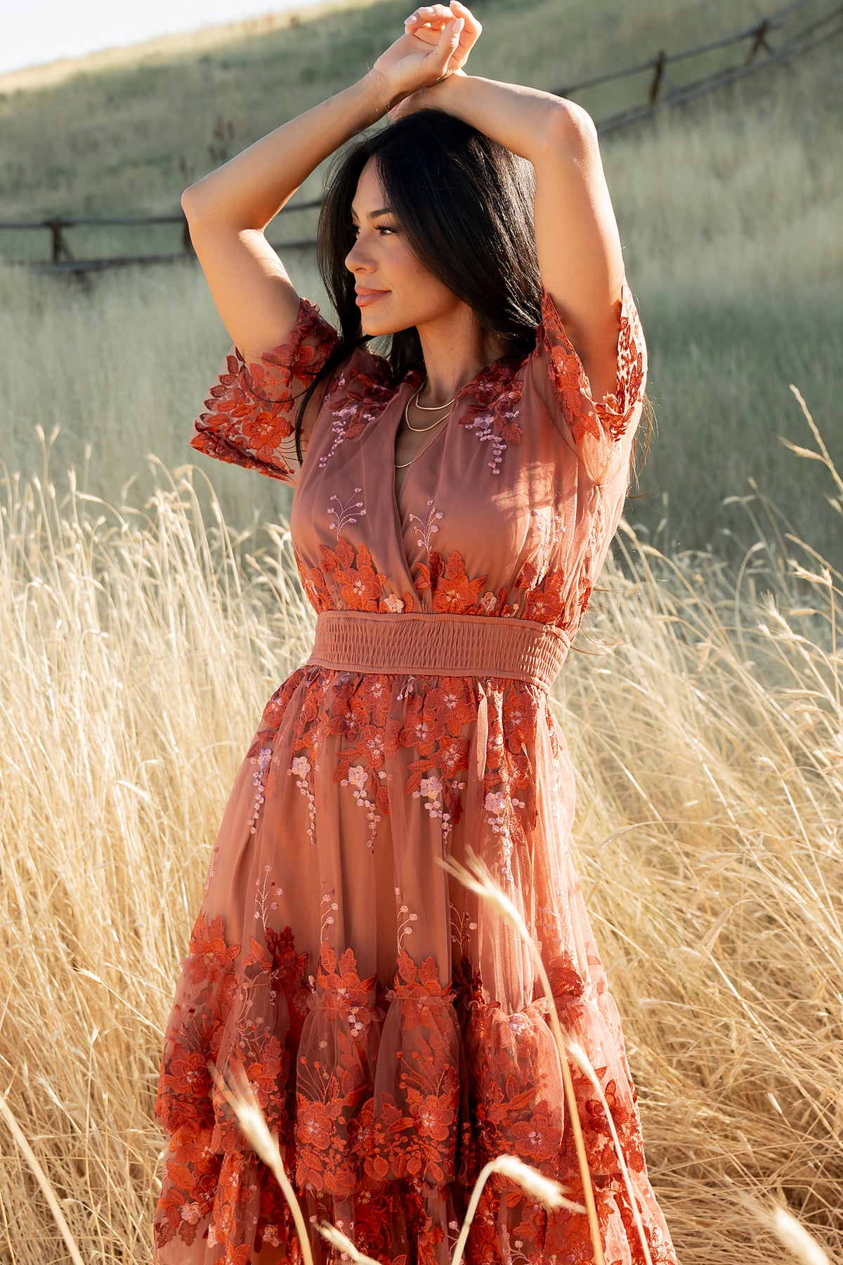 Close-up of sheer short sleeve with scalloped edge and embroidered floral detailing on the Lotte rust tulle dress.