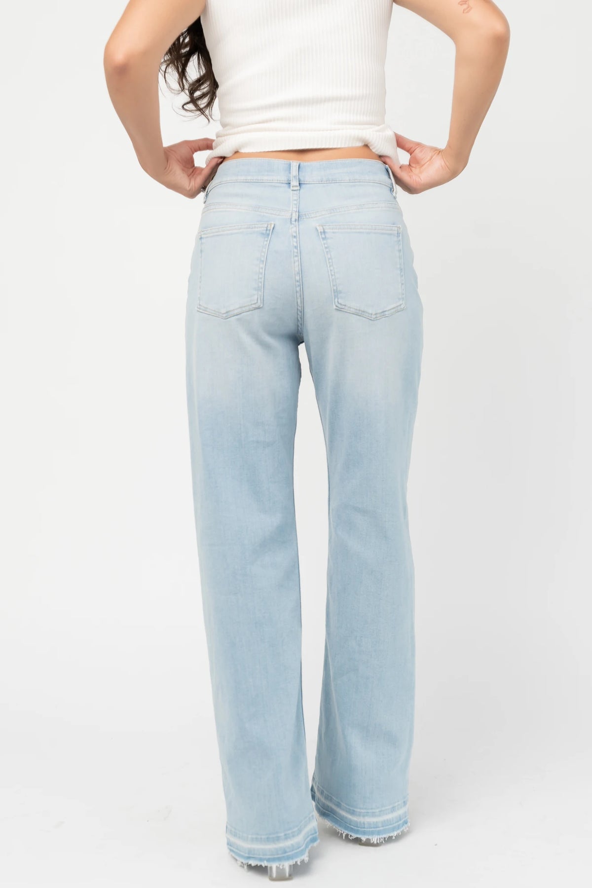 Bria High Rise Wide Leg Jeans in Light Wash with relaxed wide legs, front and back pockets, button closure, and raw hem.