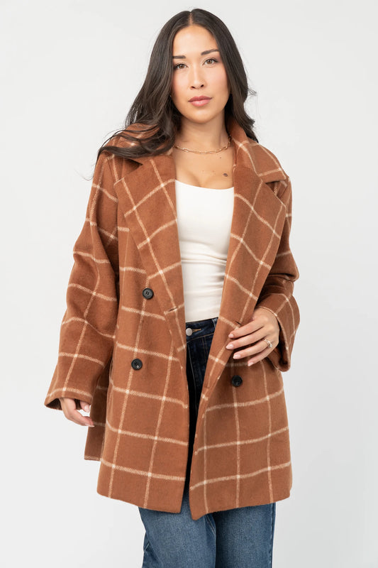 Cognac plaid mid-length coat with a cream windowpane pattern, tailored collar, button-front closure, long sleeves, front pockets, and a fully lined interior.