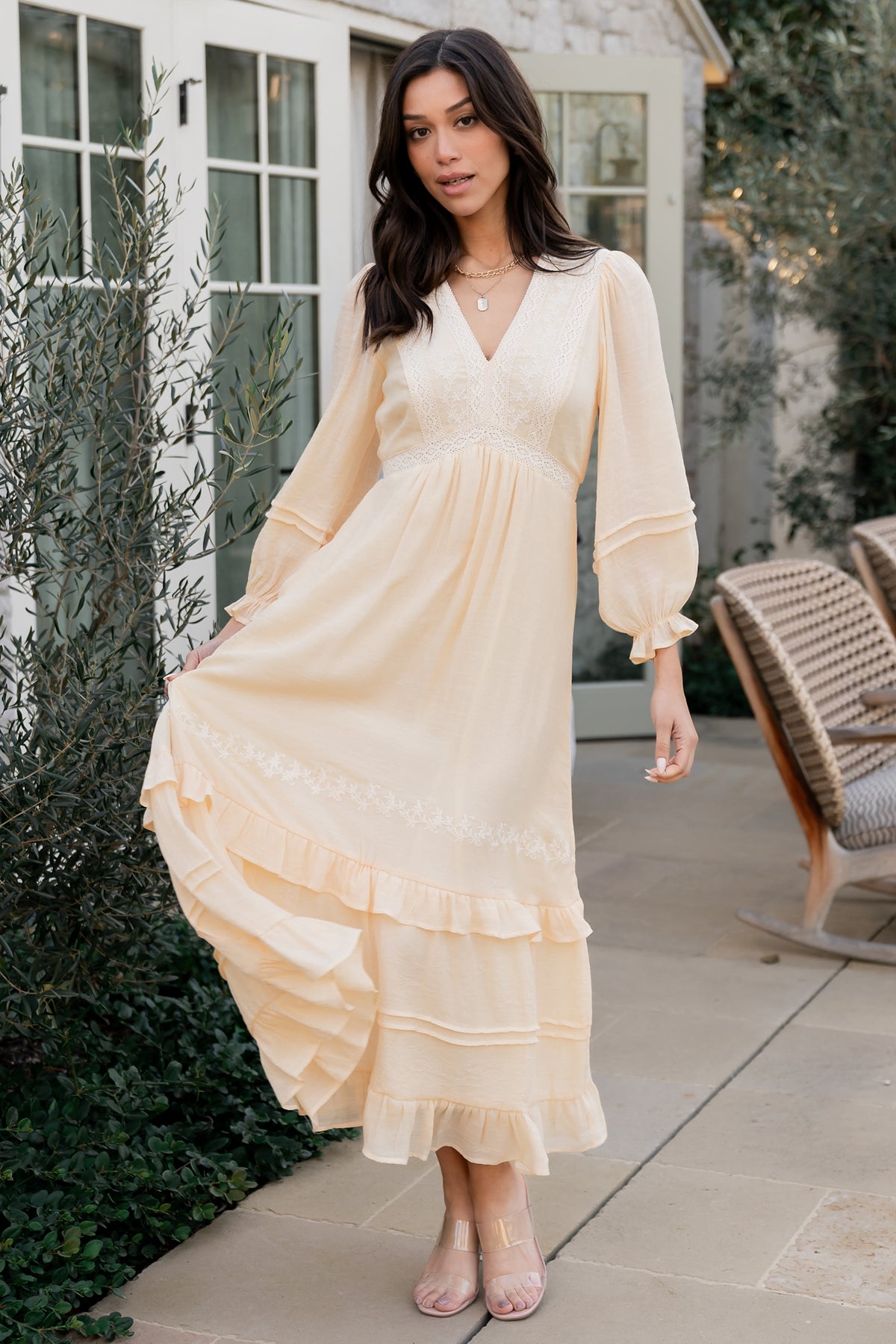 Back view of Amberlee embroidered midi dress in cream showing elastic back waist and flow of the ruffle-tiered skirt.