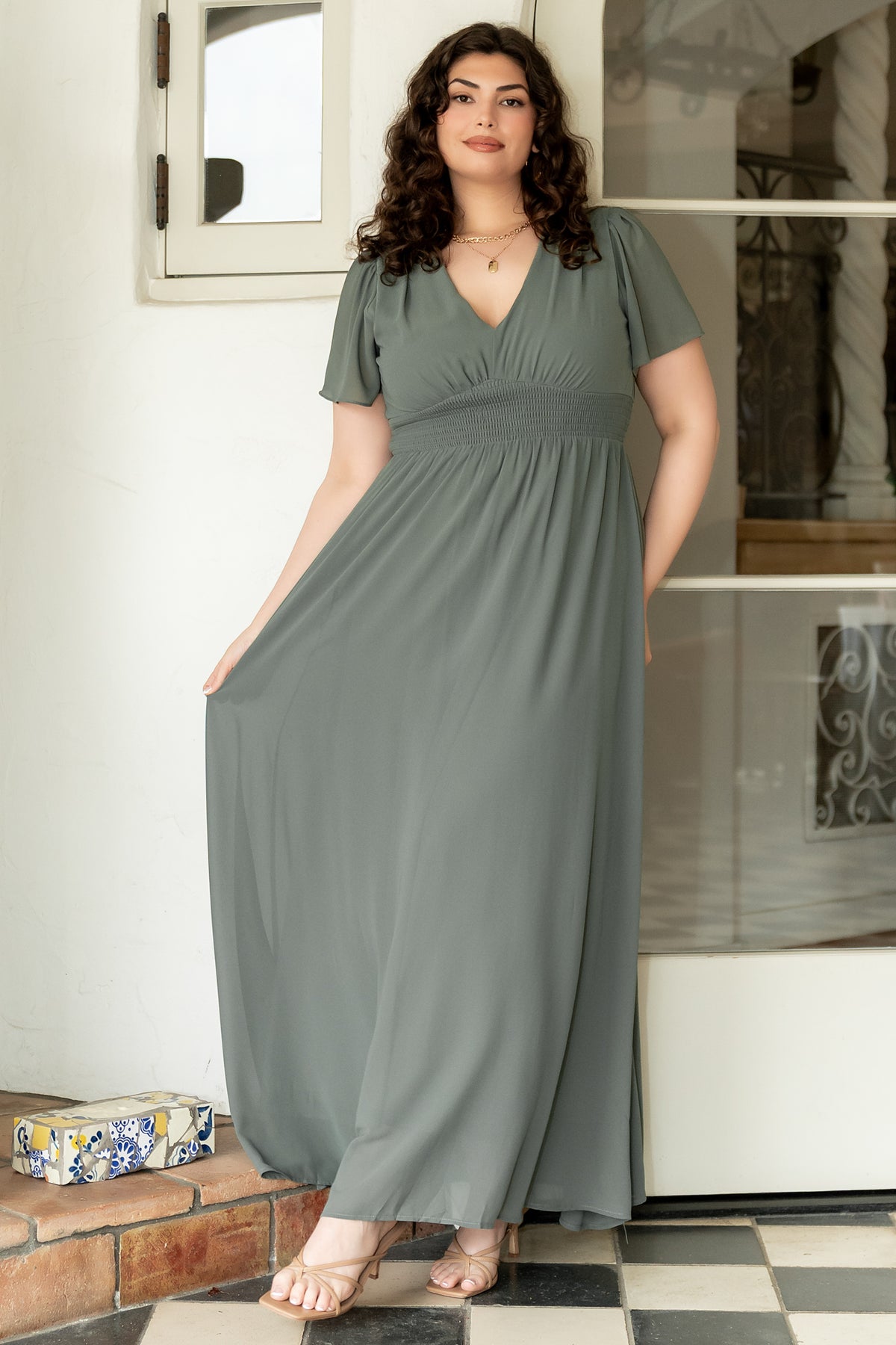 Back view of Birdie Maxi Dress in dark sage highlighting the full skirt, gentle gathers and chiffon layers at the hem for graceful movement.