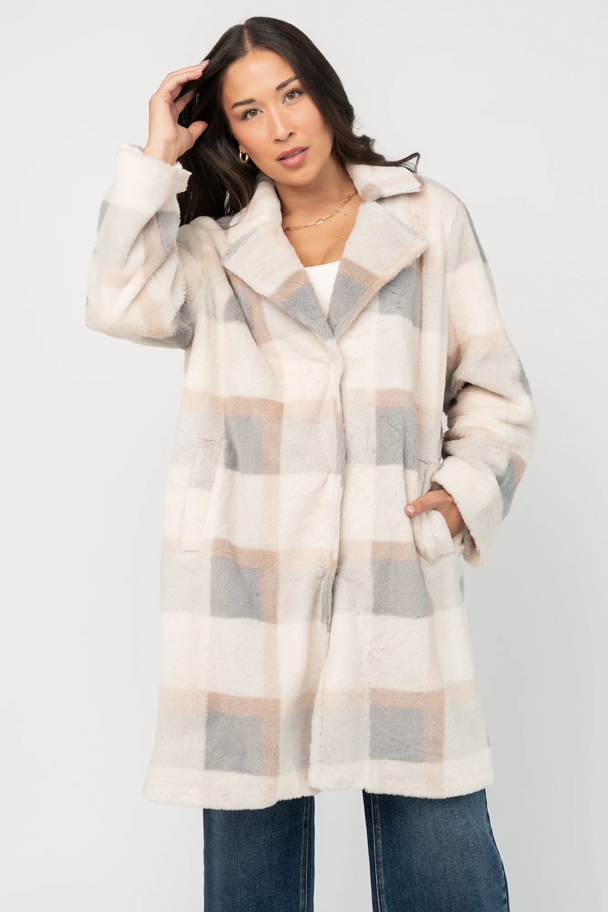 Natural plaid faux fur mid-length coat with taupe and gray accents, notched collar, hidden front snap closure, long sleeves, functional side pockets, and a fully lined interior.
