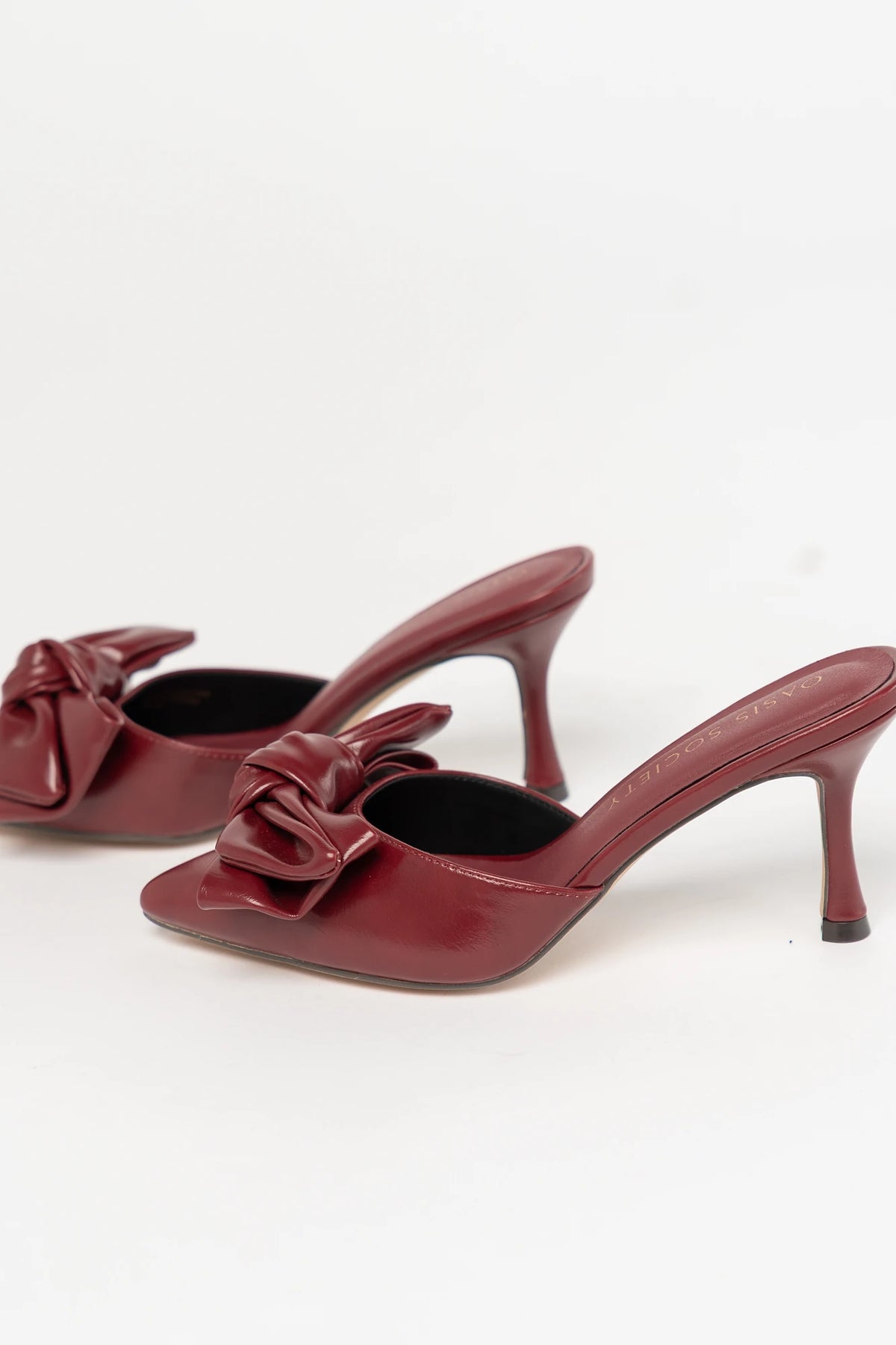 Montara Pointed Toe Kitten Heel in Burgundy with faux leather finish, statement bow, slip-on mule design, and kitten heel.