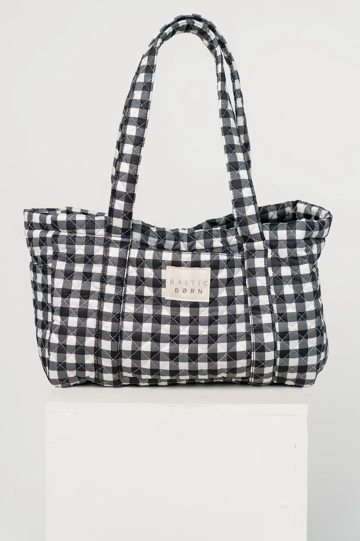 Sedona Gingham Tote Bag in Black with quilted black and white gingham, shoulder straps, snap closure, and interior zip pocket.