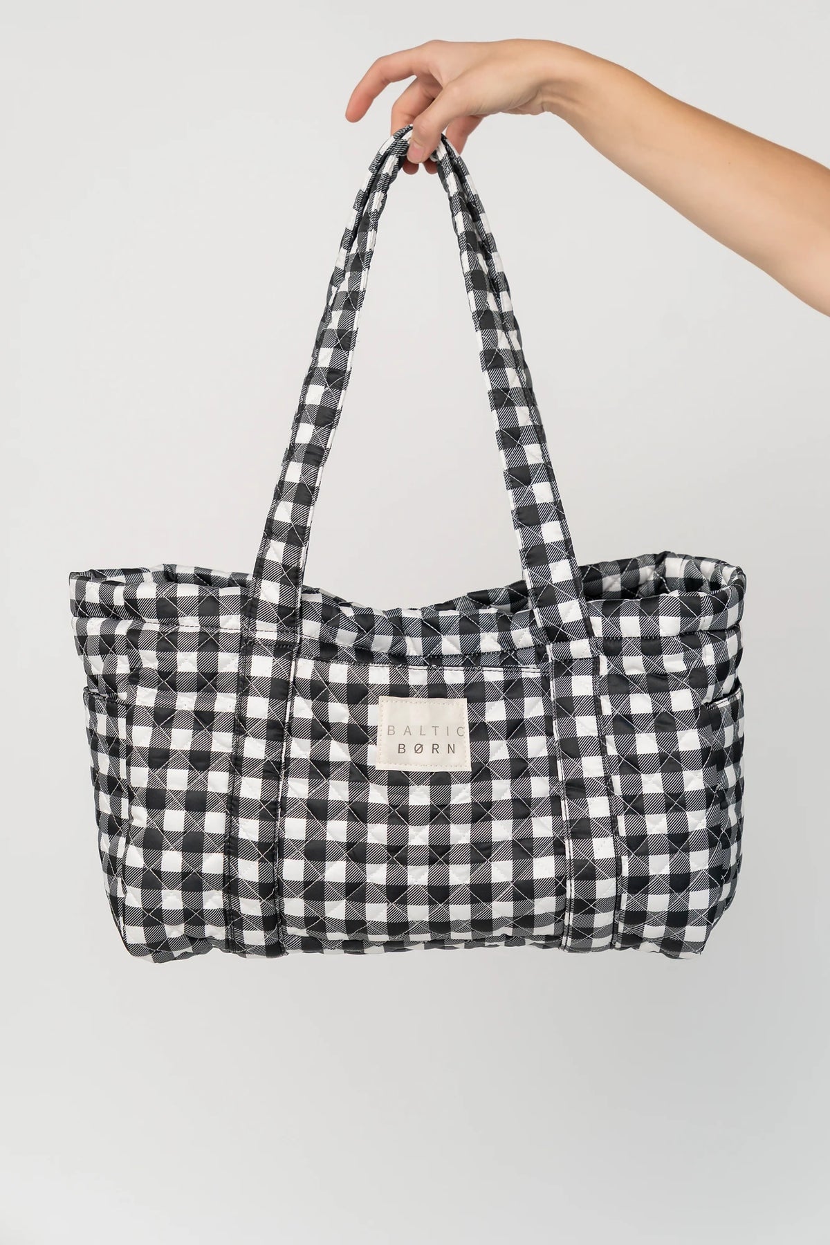 Sedona Gingham Tote Bag in Black with quilted black and white gingham, shoulder straps, snap closure, and interior zip pocket.