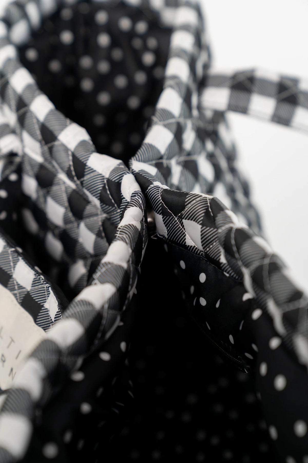 Sedona Gingham Tote Bag in Black with quilted black and white gingham, shoulder straps, snap closure, and interior zip pocket.