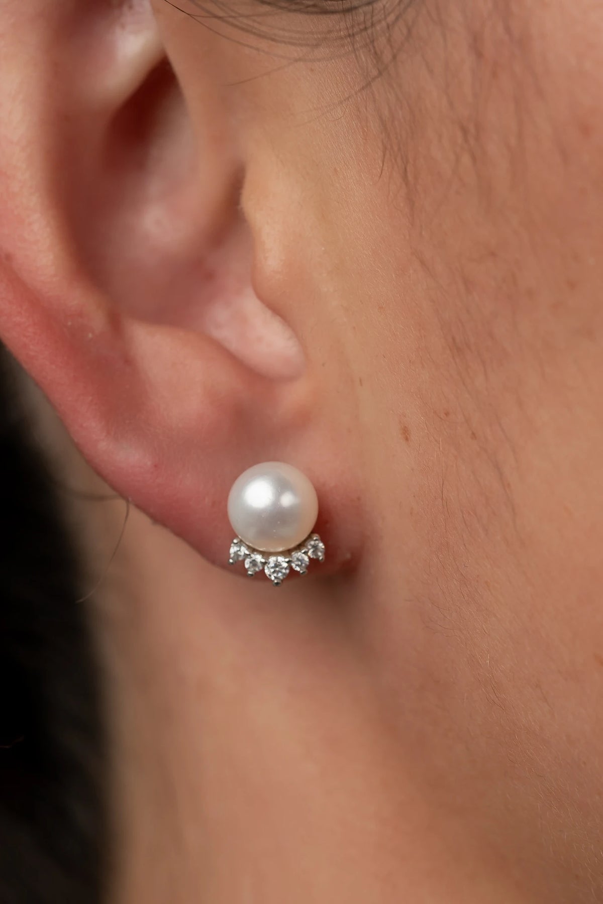 Livvy Pearl Stud Earrings with glossy pearl centers, polished sterling silver settings, and classic post backs.