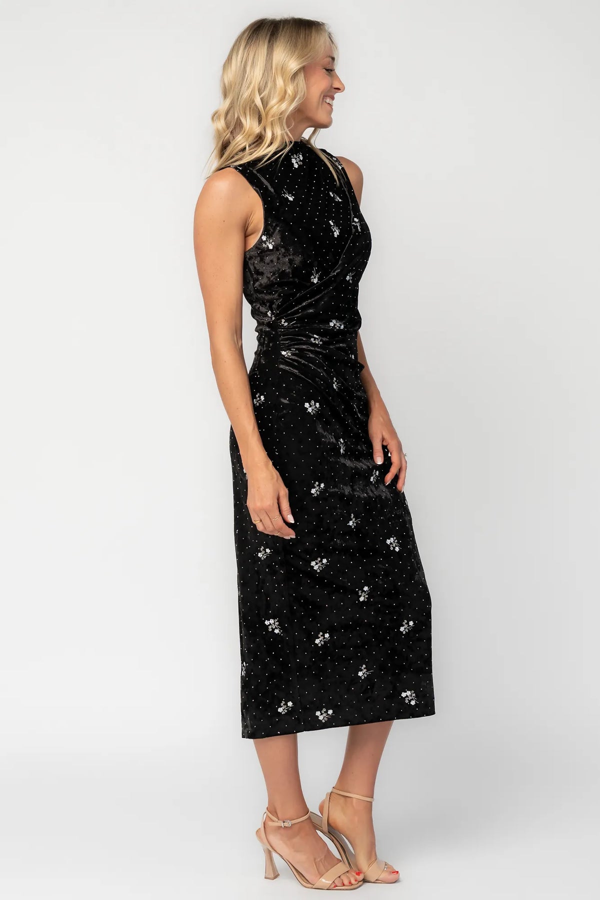 Model wearing a black velvet midi dress with a high neckline and fitted silhouette.