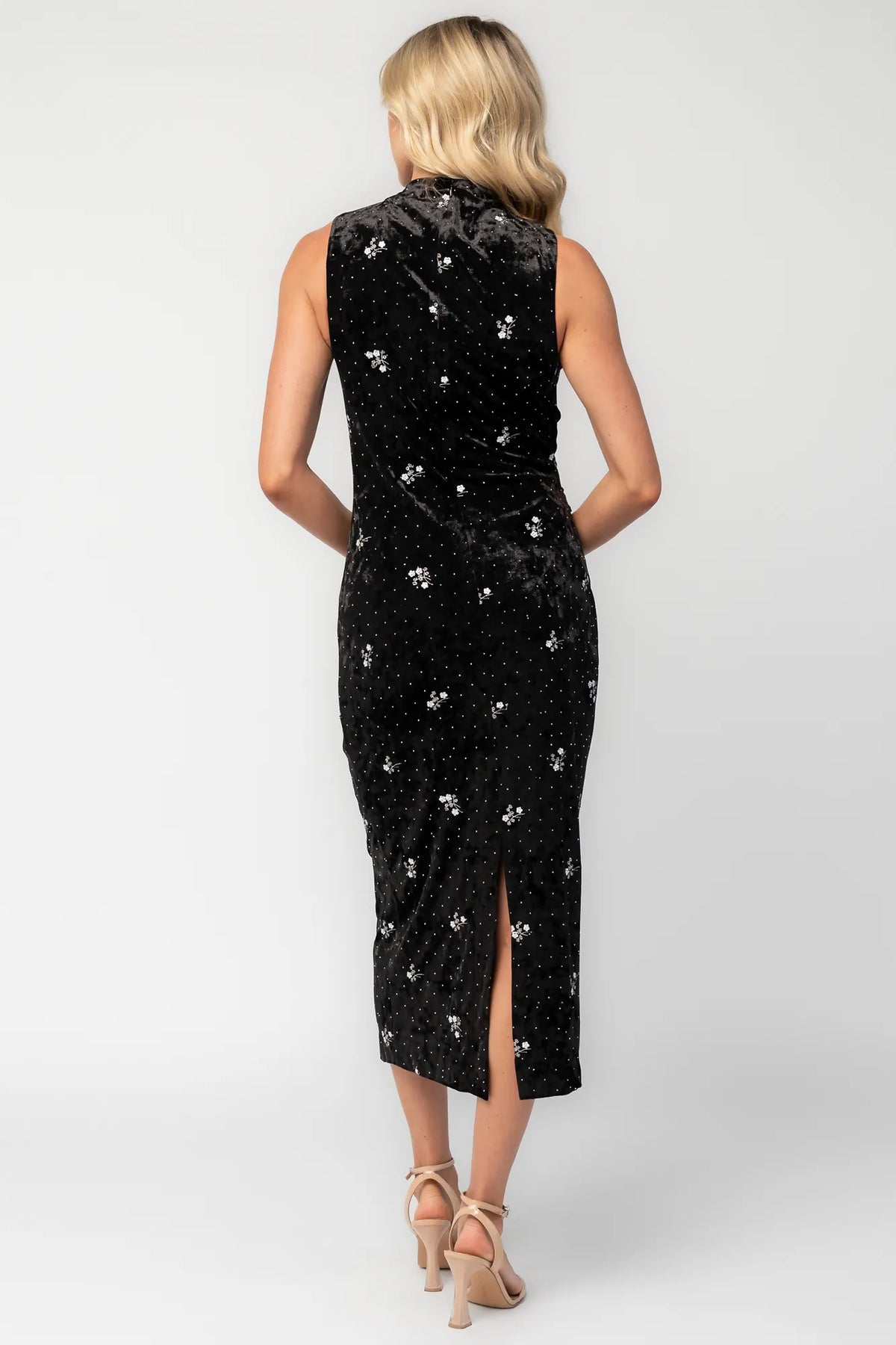Model wearing a black velvet midi dress with a high neckline and fitted silhouette.