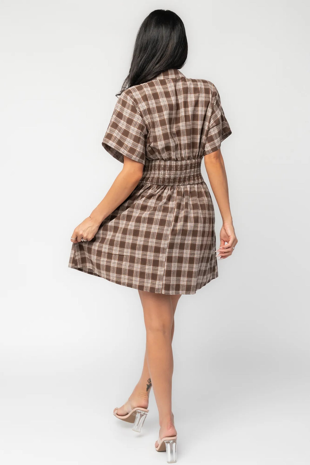 Model wearing a brown plaid short dress with a collared neckline, button-front closure, and short dolman sleeves.
