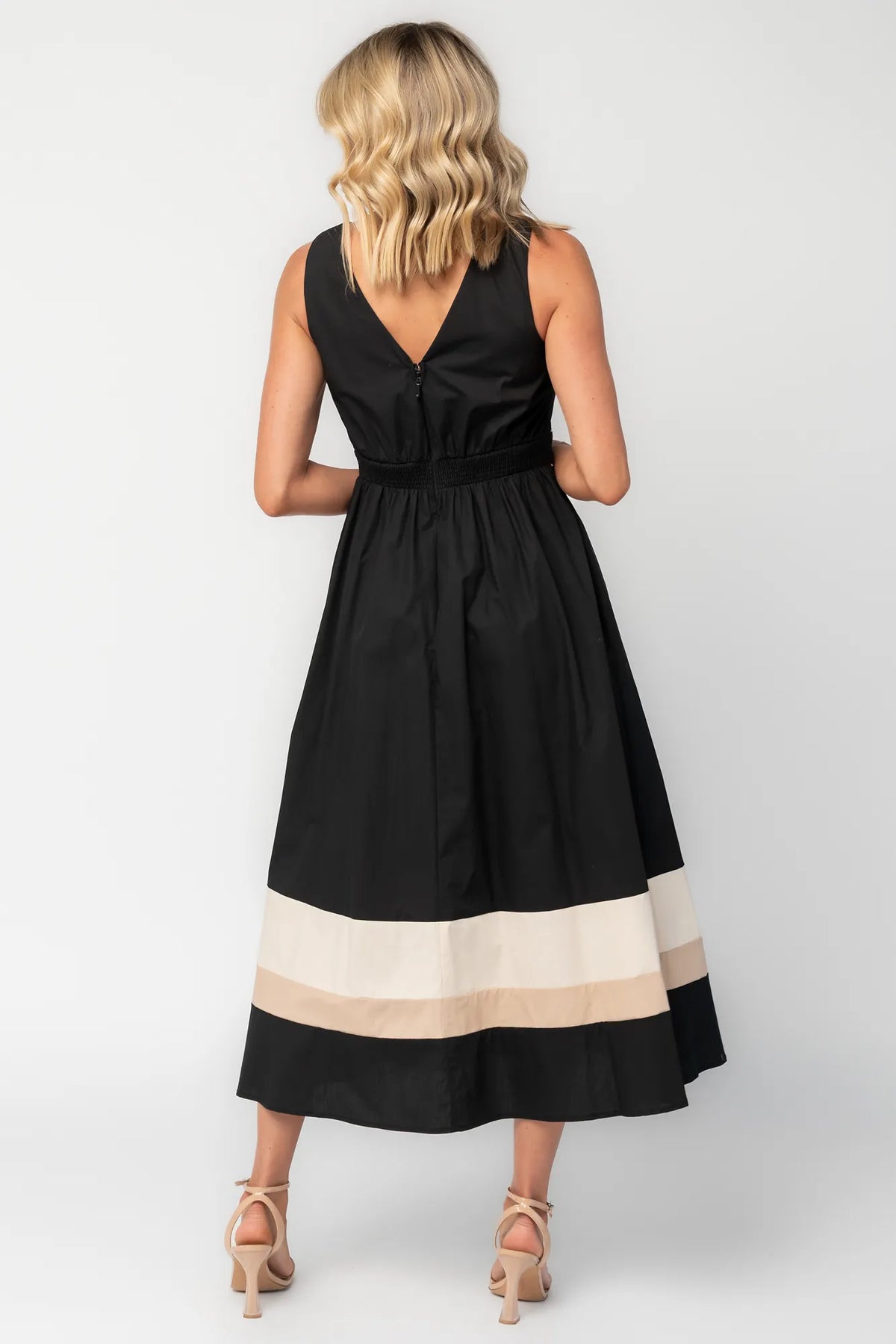 Model wearing a black midi dress with a V-neckline, tank straps, and a fitted bodice.